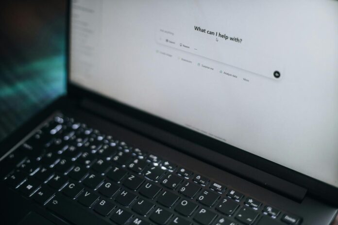 Laptop menampilkan "apa yang bisa saya bantu?"